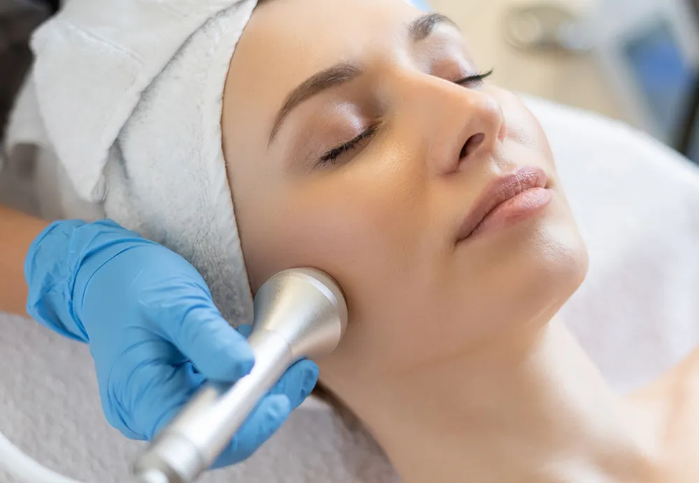 Dermatologist performing a laser toning treatment on a patient’s face 1000x692