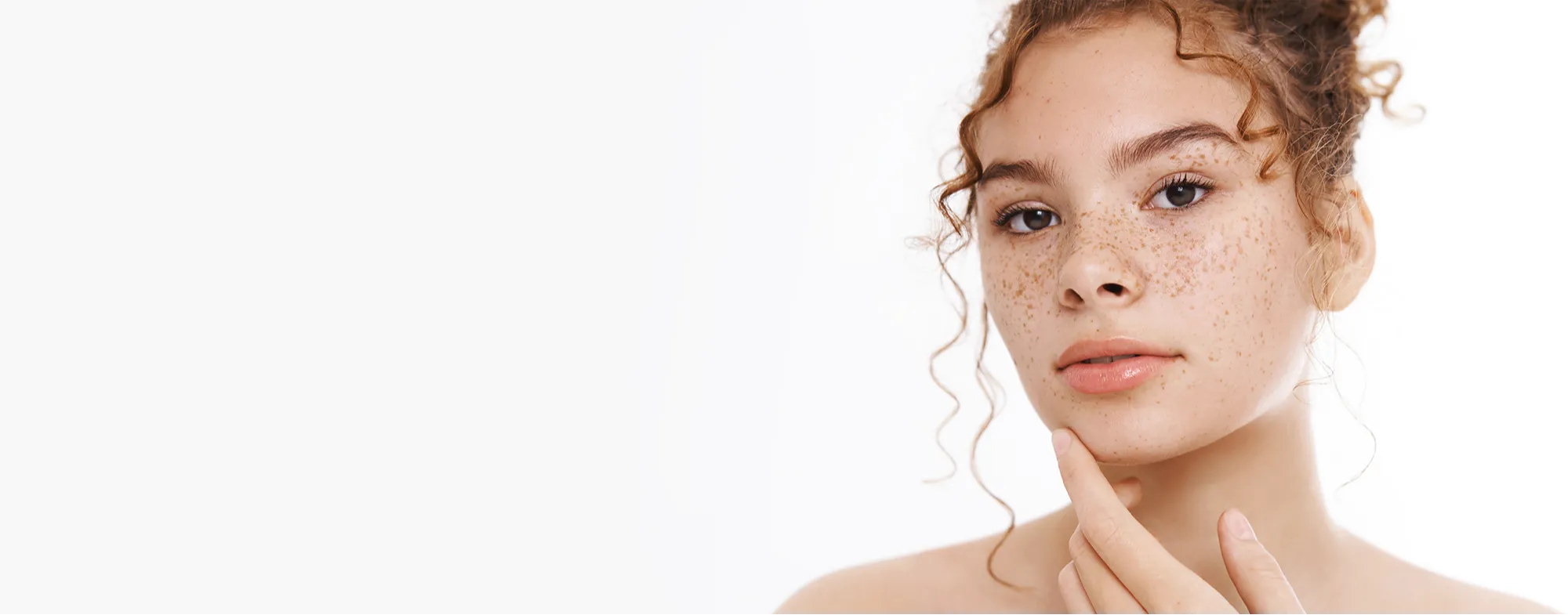 Close up of a woman with freckles next to text advertising pigmentation treatment at Dermatrix clinic 2000x785