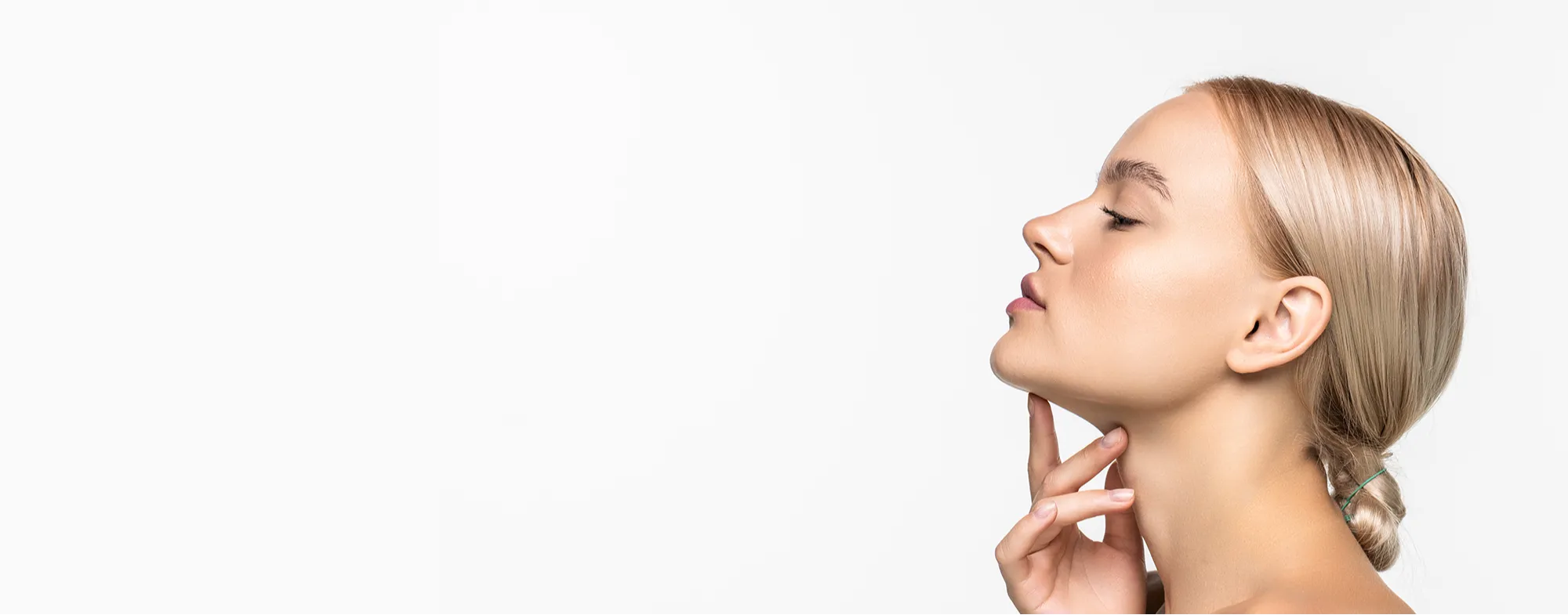 Profile view of a woman showing a defined jawline after a non surgical chin sculpting treatment at Dermatrix 2000x785