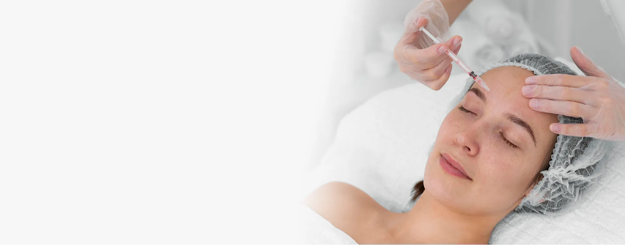 Dermatrix practitioner performing a GlowTox treatment combining Botox and hyaluronic skin boosters on a client's forehead for skin rejuvenation 2000x785