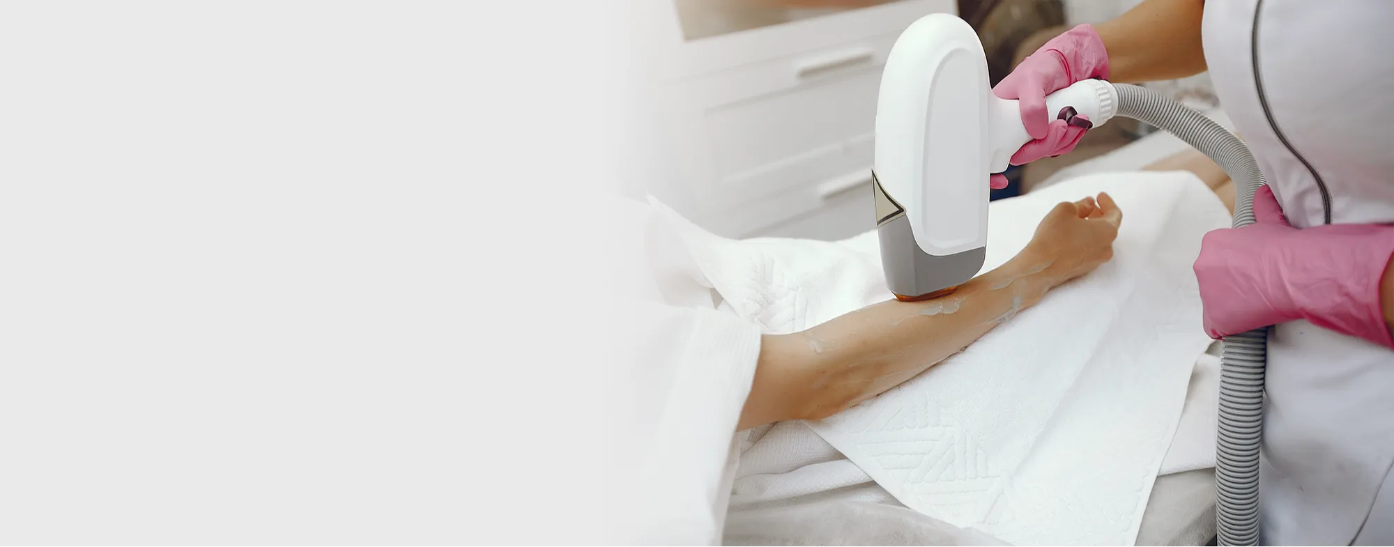 Dermatologist performing advanced laser hair removal treatment on a patient's arm at Dermatrix clinic 2000x785