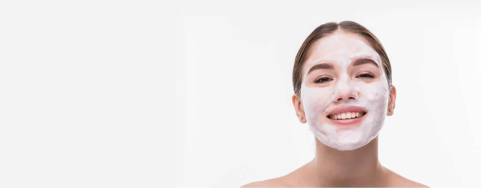 Smiling woman receiving a professional Dermatrix Medi Facial treatment with white foam cleanser for skin rejuvenation 2000x785